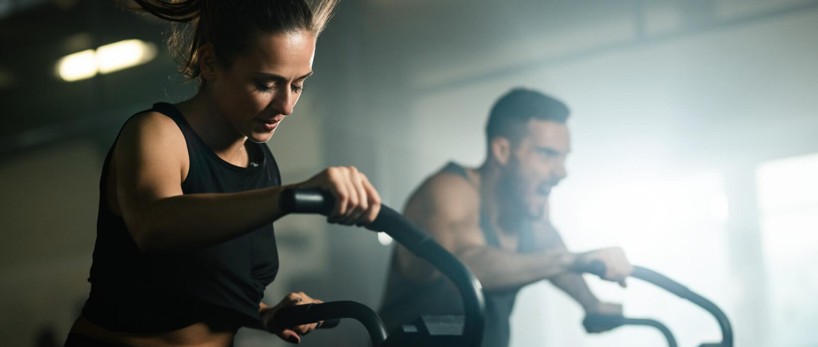 A women and a man working out on a HIIT machine.