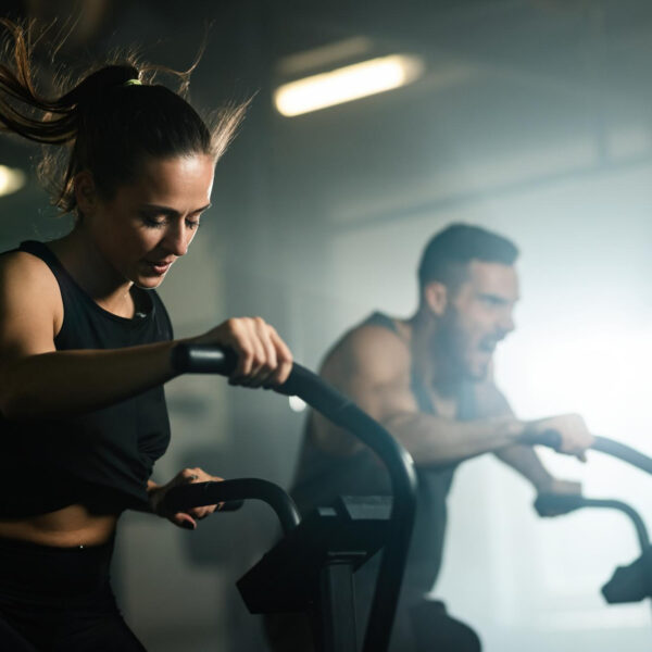 A women and a man working out on a HIIT machine.