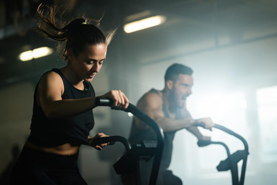 A women and a man working out on a HIIT machine.